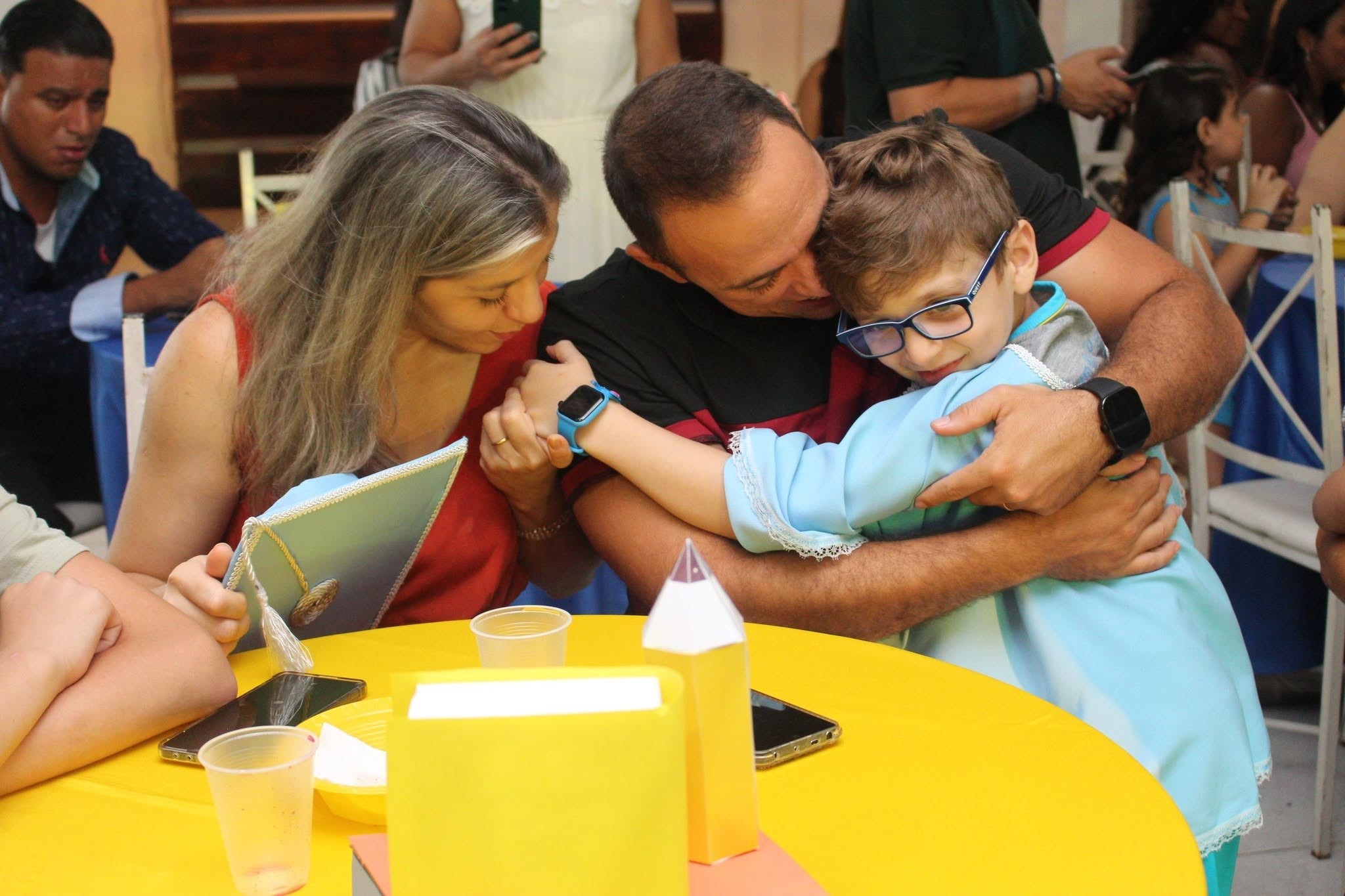Família abraçando o filho, aluno da CRELEM